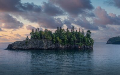 Ellingson Island glows in the morning light as Lake Superior’s calm waves meet r…